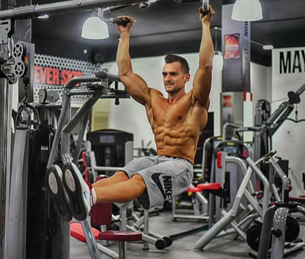 Samir Chebbo performing a hanging leg raise in the gym