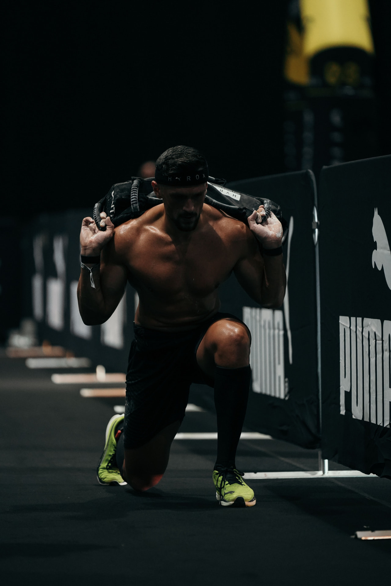 Samir Chebbo carrying a sandbag during a HYROX lunge