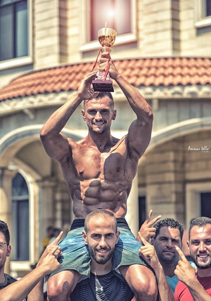 Samir Chebbo lifted on shoulders holding a competition trophy