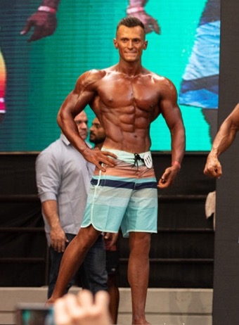 Samir Chebbo posing on a bodybuilding competition stage