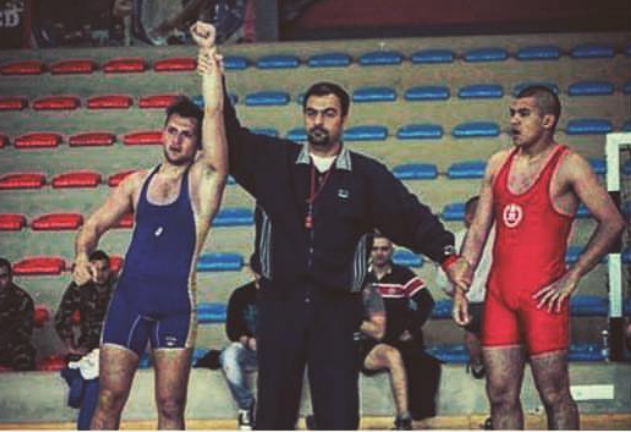 Samir Chebbo declared winner of a wrestling match, arm raised by the referee
